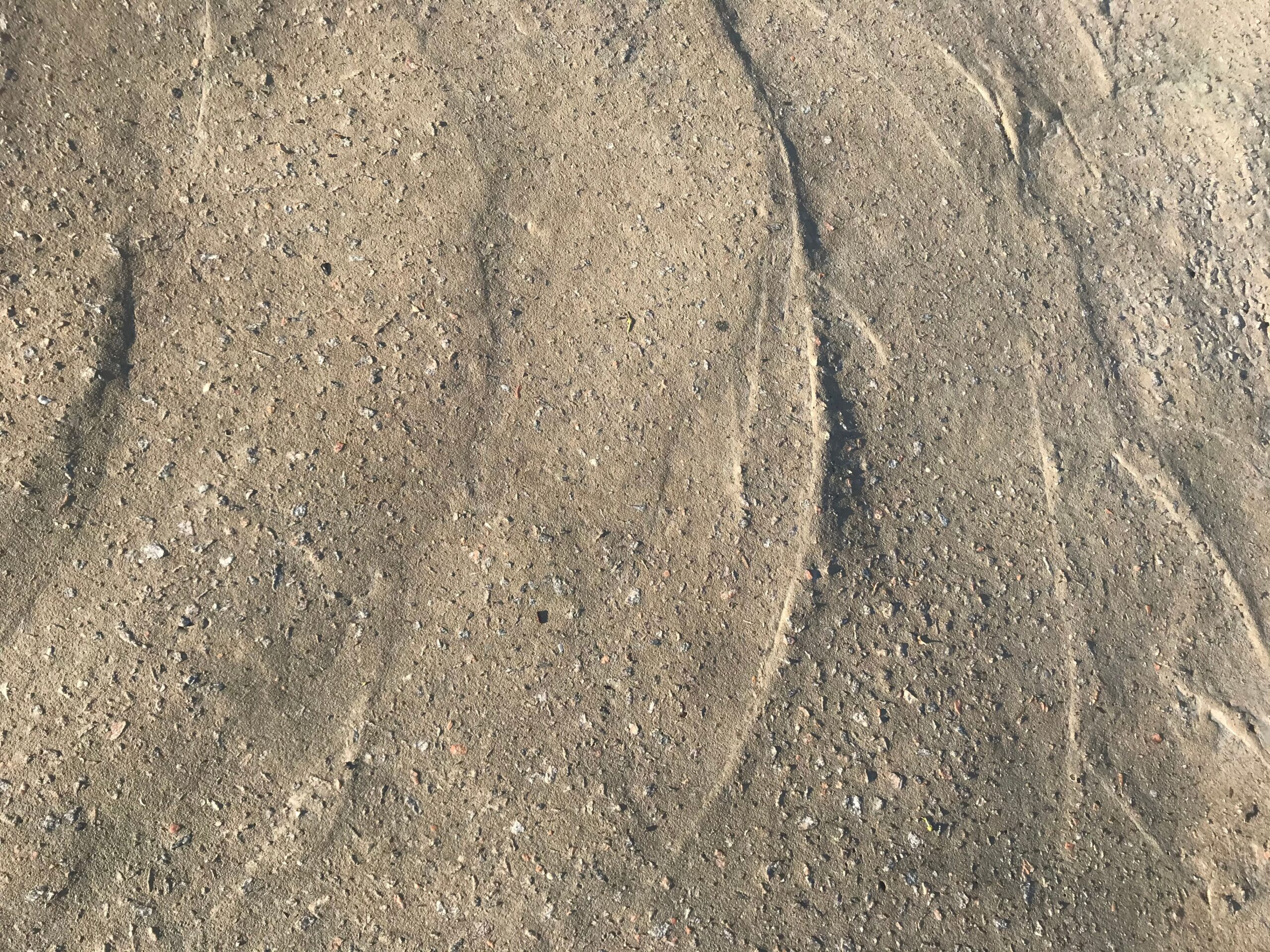 Close-up view of a textured sand surface showcasing natural patterns and rough texture.