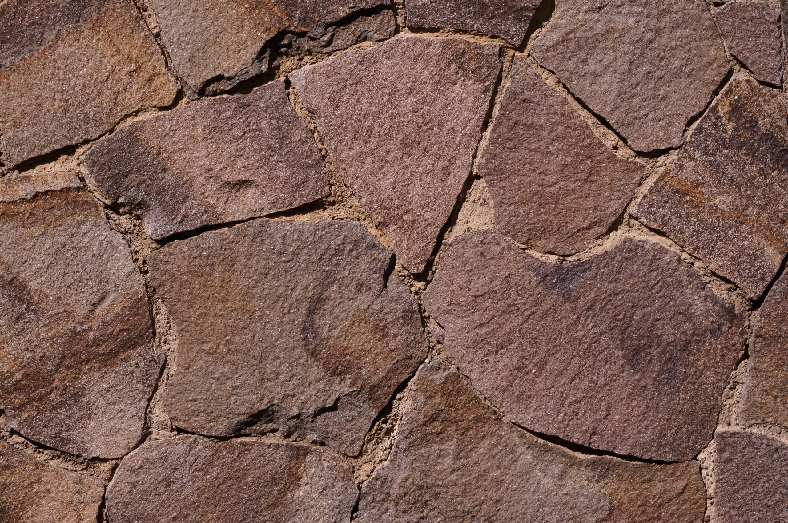 Detailed view of a rustic stone wall texture, perfect for backgrounds or architectural designs.