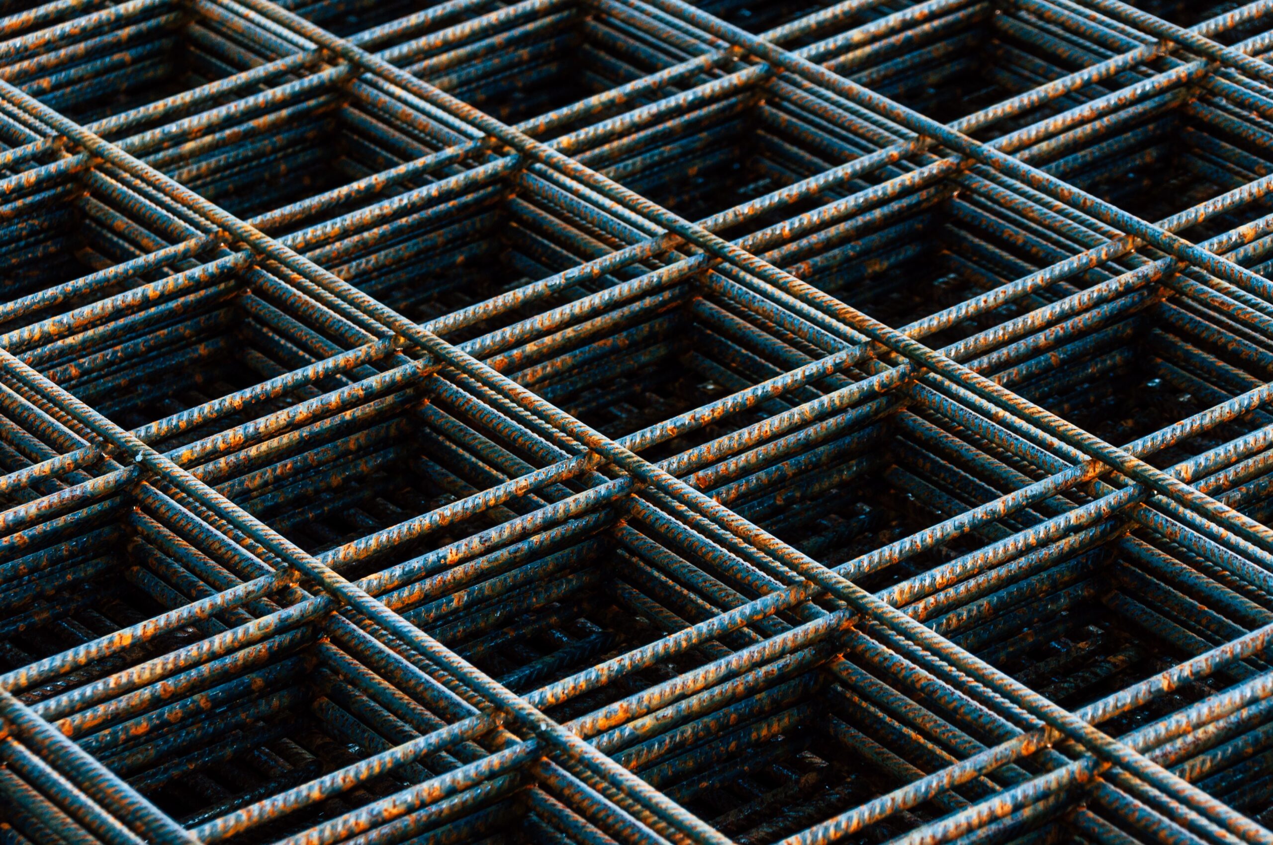 Detailed view of a rusty rebar grid used in construction work, showing texture and pattern.
